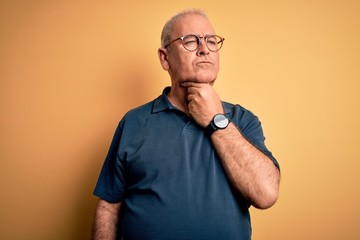 Middle age handsome hoary man wearing casual polo and glasses over yellow background Touching painful neck, sore throat for flu, clod and infection