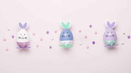 Funny kawaii cute bunny eggs in pastel colors on pink table top, Easter holiday concept. Easter decoration for kids still life, copy space