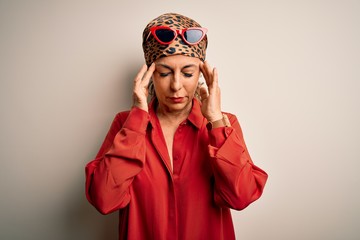 Middle age brunette woman wearing handkerchief on head and shirt over white background with hand on head for pain in head because stress. Suffering migraine.