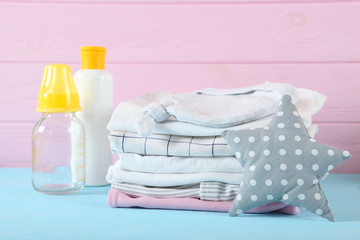 a stack of baby clothes on a light background.
