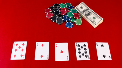 poker chips, dollars, cards on a red gaming table