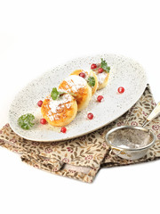 food photography of diet dish cheese pancakes (syrniki) side view with sugar powder and berries on white background isolated close up