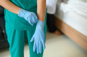 Closeup of a nurse in scrubs putting surgical gloves , Preparing equipment for surgery in operation room