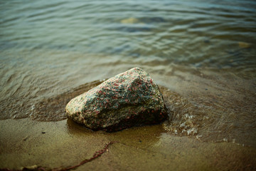 Fototapeta na wymiar Stein im Wasser am Strand in Tampere, Finnland