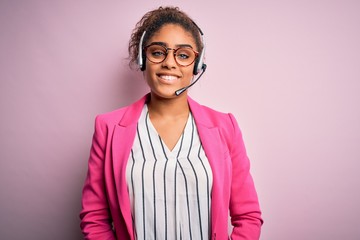 Young african american call center agent girl wearing glasses working using headset with a happy...