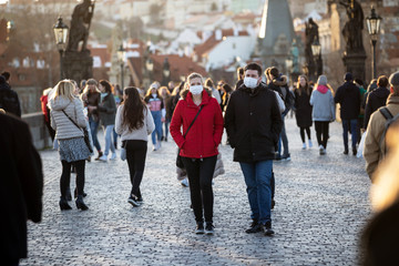 Couple walking with protected faces by the veils threw historical centrum in Prague, Czech Republic, World during pandemic of coronavirus.