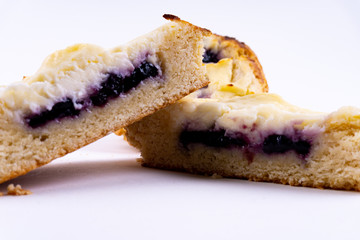 A cut cookie cheesecake with blueberries on white background with copy space - angled view
