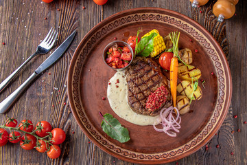 Filet mignon steak served with grilled vegetables, mushrooms and cheese sauce, restaurant dish,...