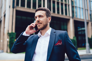 Confident businessman answering phone call on roadside