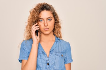 Young beautiful blonde woman with blue eyes having conversation talking on the smartphone with a confident expression on smart face thinking serious