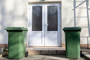 garbage containers near the door on the street