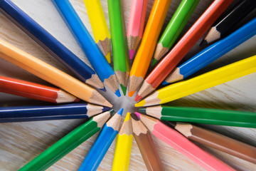 Fototapeta premium Colored pencils lie in a circle on a table
