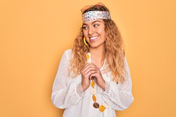 Young beautiful blonde hippie woman with blue eyes wearing sunglasses and accessories laughing...