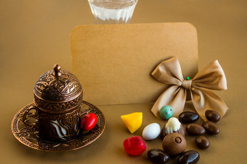 Traditional Turkish copper,coffee cup with colorful almond candies and an empty card for any celebration text.