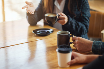 Closeup image of people enjoyed talking and drinking coffee together in cafe