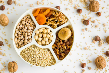 Ingredients of ashura dessert ;walnut,hazelnuts,wheat,apricot,fig,grape and chickpea in the divided plate.Top view.