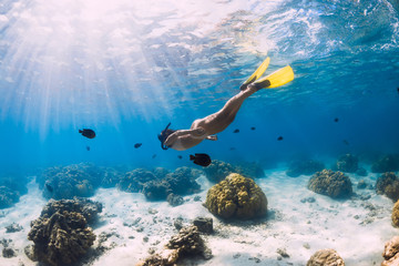 Woman freediver swimming over with yellow fins in ocean. Freediving or snorkeling in Mauritius