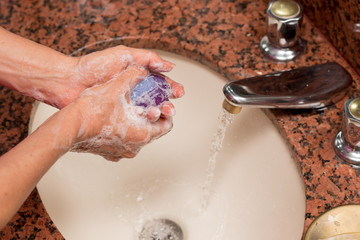 Woman Washing her Hands with Soap and Water in the Sink