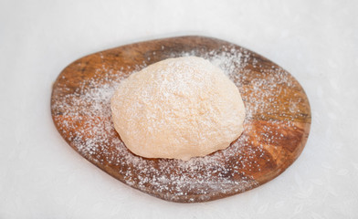 dough for pizza on white table on Board top view