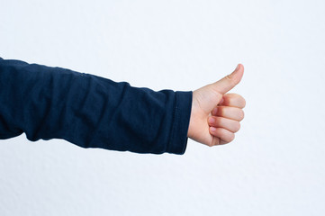 Childs hand with thumb up. Positive gesture of acceptation, ok, agreement, success.