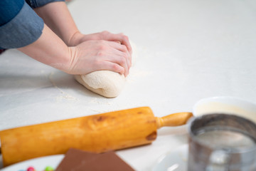 women hands knead yeast dough for pie or pizza.