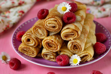 Obraz na płótnie Canvas Stack of thin pancakes crepes served with raspberries