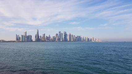 Buildings on bank of the deep sea with cloudy sky