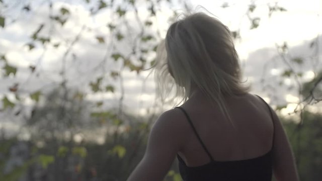 Junge Frau tanzt fr&ouml;hlich umgeben von Herbstb&auml;umen