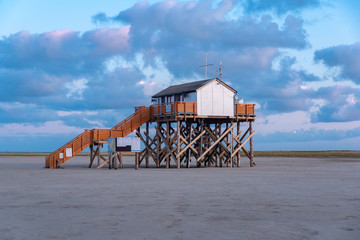 Fototapeta na wymiar Stilt houses on the beach of St Peter-Ording