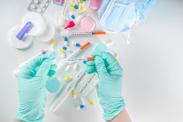 Fototapeta premium Hands in protective gloves holding syringe over medical supplies