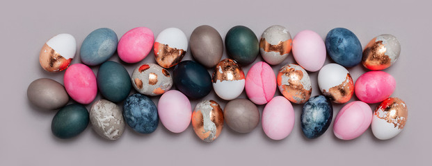 Fototapeta na wymiar Pattern of pink and blue eggs on a gray background.