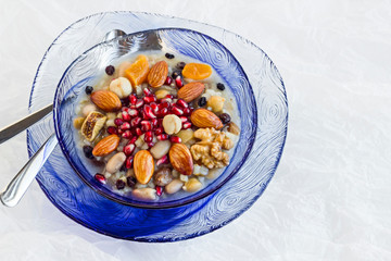 Traditional Turkish Dessert Asure,Noah Pudding in stylish blue color,glass bowls on the flimsy,white paper with copy space.