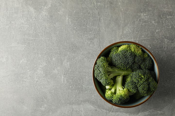 Bowl with broccoli on grey background, top view. Healthy food