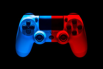 White video game joystick gamepad in blue and red neon lights isolated on black