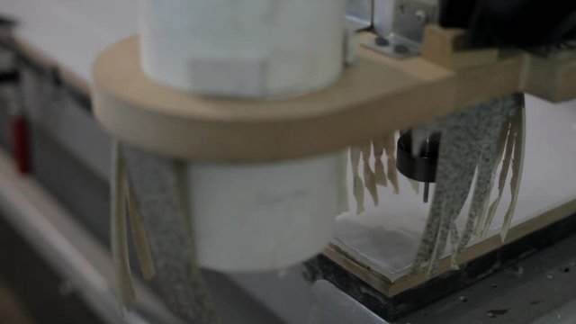 Machine for cutting plastic and wood. The work of the machine. Tablet plotter at work. Cutting the material in shape. Production of promotional materials. Drilling solid material with a CNC controlled