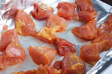 Delicious and satisfying pieces of pork with seasonings on foil. Preparation for baking in the oven. Raw pork. Meat. Meal