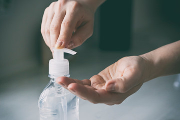 The woman applying the sanitizer on her hand at home