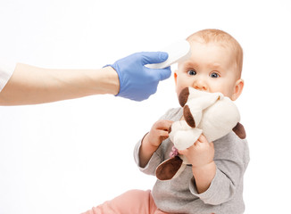 Pediatrician using infrared thermometer checking body temperature of baby boy