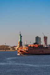 Statue liberty at sunset with ferry
