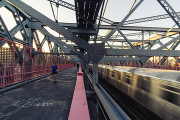 Fototapeta na wymiar Train passing by and runner on the manhattan bridge