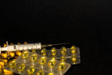 On black background lies tablets, medical mask, syringe, medicines. Coronavirus 19.