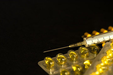On black background lies tablets, medical mask, syringe, medicines. Coronavirus 19.