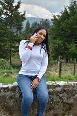 Mujer morena latina madura sexy hablando por teléfono y sonriendo 