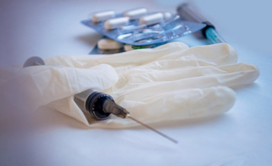 layout, on the glove lies a syringe and a blister with tablets. toned in blue
