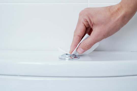 Man Flushing The Toilet Protected With Paper