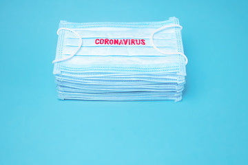 Coronavirus background. Epidemic backround. Facial mask in the pile. Quarantine background. Healthcare background. Blue medical disposable face mask with covid-19 print. Facial mask wholesale, in pile