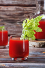 Glass of tomato juice on a wooden table, on a wood background, fresh drink