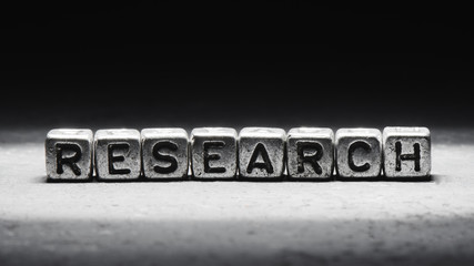 The word research on metal cubes on a black background
