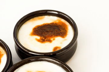 Traditional Turkish Style Baked Rice Pudding in casserole,clay dessert bowls,on white surface with copy space