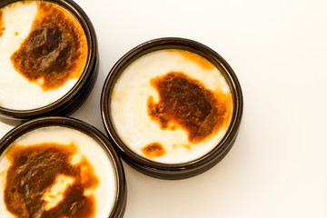 Traditional Turkish Style Baked Rice Pudding in casserole,clay dessert bowls,on white surface with copy space,top view
